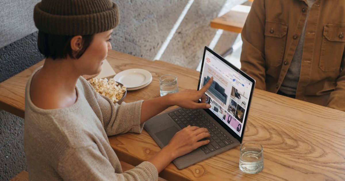 Pessoa a usar um computador portátil e a analisar várias ofertas de alojamento web durante a época de promoções Black Friday ou Cyber Monday.