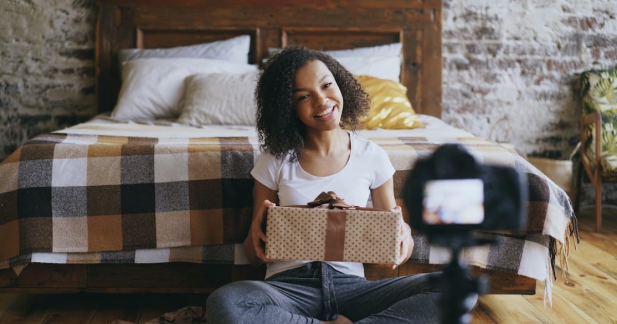 Mulher a usar um smartphone para fazer um pagamento online, com o logótipo MB WAY visível no ecrã e um cartão Multibanco ao lado, num ambiente de comércio eletrónico.