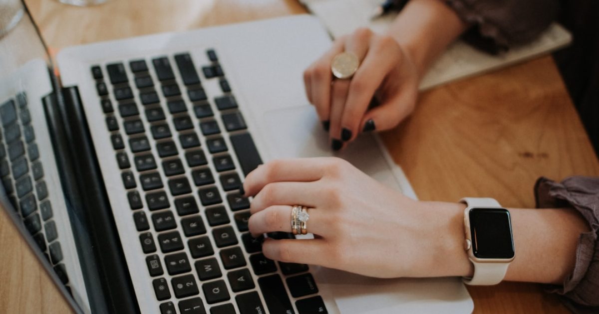 Mãos a trabalhar num portátil, simbolizando a gestão e transferência de um domínio online para a plataforma AlgarIT